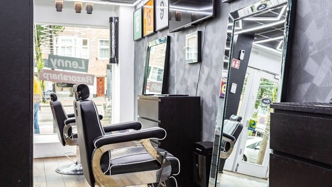 Een barberstoel voor een grote spiegel, met het raam naar de Rijnstraat erachter